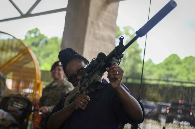 Nashville producer Wendy Calhoun handles a rifle on a tour of Air Force Special Ops Command